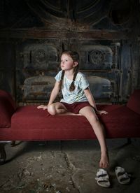 Full length of a girl sitting on wall