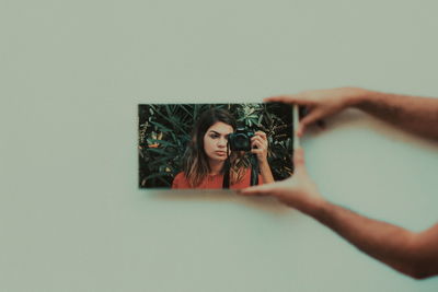 Close-up of woman photographing against white background