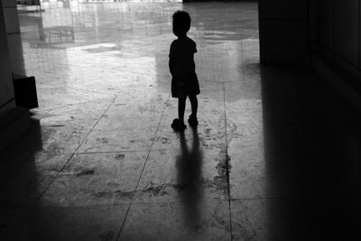 Rear view full length of silhouette boy standing on walkway