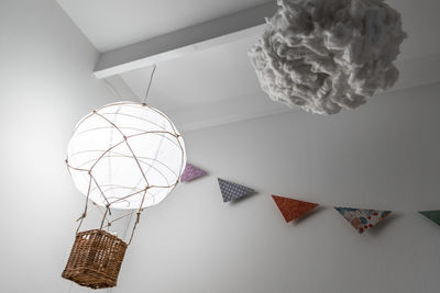 Low angle view of illuminated lighting equipment hanging on wall at home