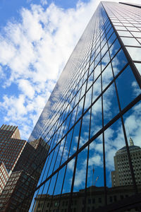 Low angle view of modern building against cloudy sky