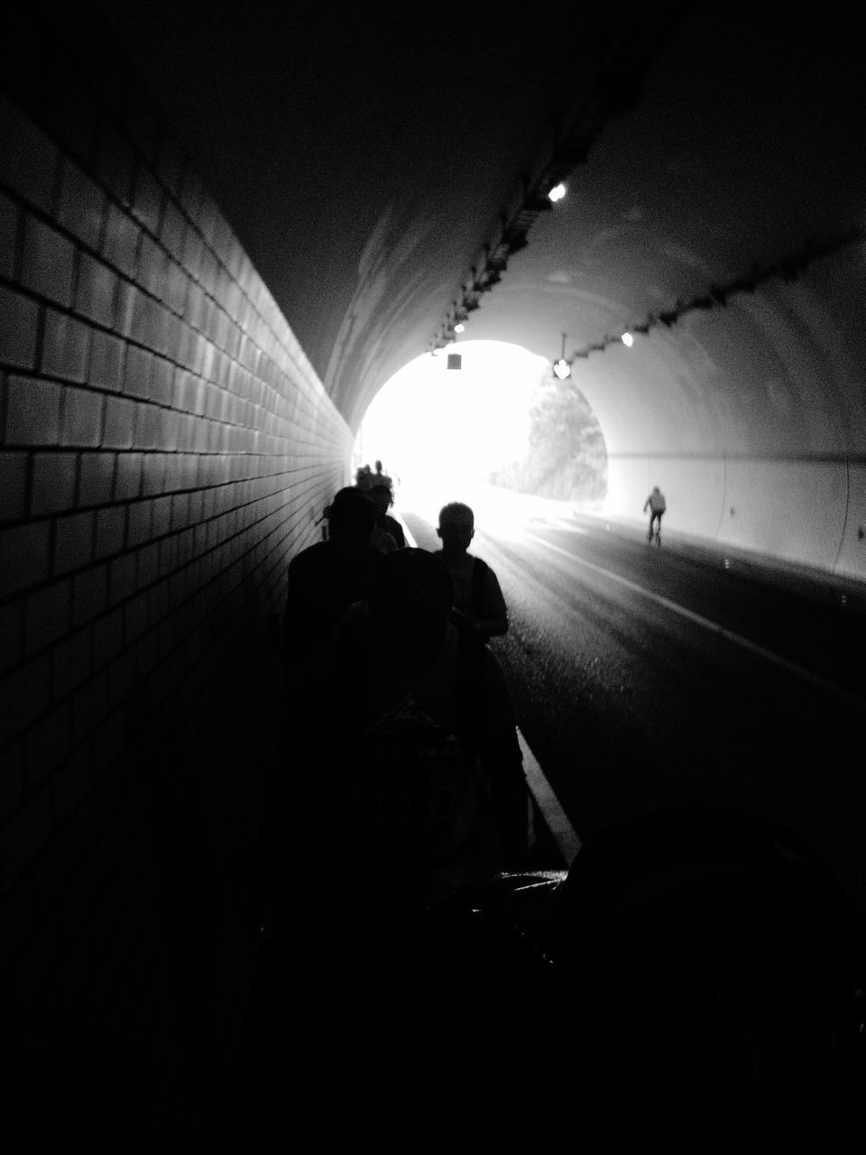 indoors, tunnel, illuminated, silhouette, men, rear view, lifestyles, dark, night, leisure activity, transportation, full length, built structure, architecture, the way forward, walking, person