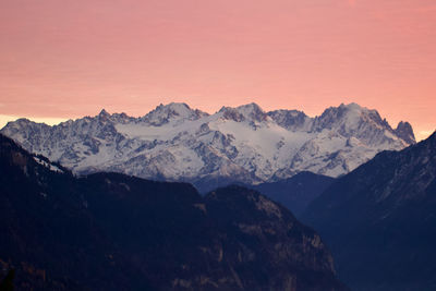 Scenic view of snowcapped mountains against sky during sunset