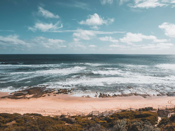 Scenic view of ocean and waves against sky