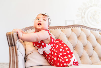 Cute girl sitting on sofa at home