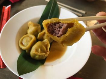 Close-up of hand holding food in plate