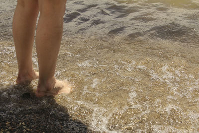 Low section of woman standing on beach