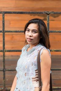 Portrait of woman standing by gate