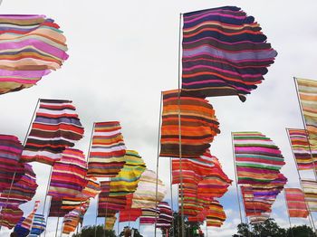 Low angle view of multi colored umbrellas against sky in city