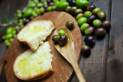 High angle view of olives with bread on cutting board