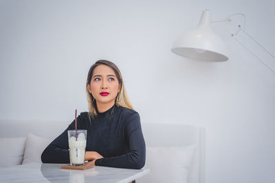 Portrait of young woman sitting on table