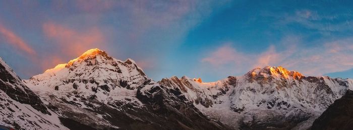 Scenic view of snowcapped mountains against sky during sunset