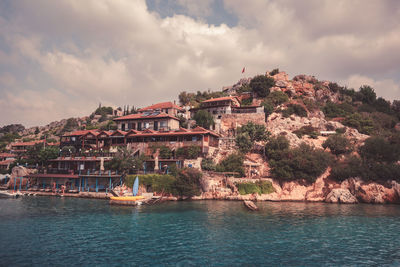 Buildings by river against sky