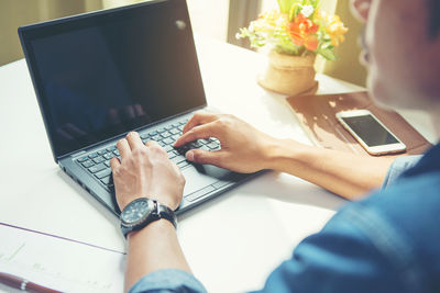 Low section of woman using laptop on table