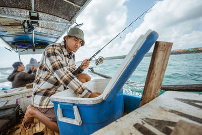 Rear view of man sitting on boat