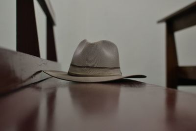 Close-up of hat on table against wall at home