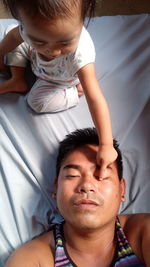 Cute daughter playing with father at home