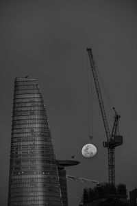 Low angle view of crane against clear sky
