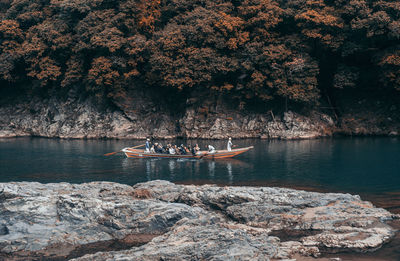 People on rock by lake