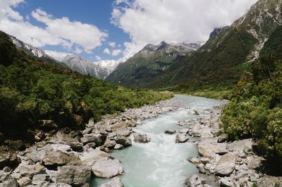 Scenic view of stream amidst mountains against sky