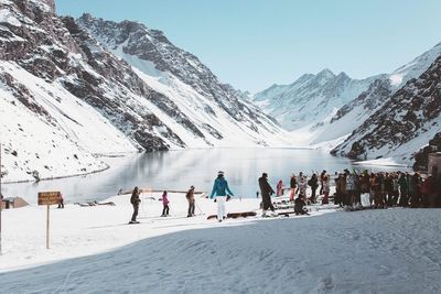 Panoramic view of people skiing against snowcapped mountains