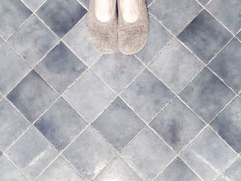 Low section of person standing on tiled floor