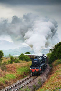 Train on railroad track against sky