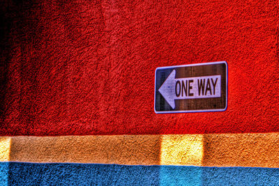 Close-up of information sign on red wall