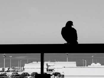 Silhouette man with arms raised against sky