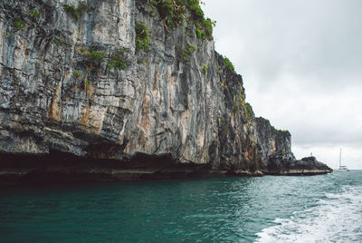 Rock formation in sea against sky