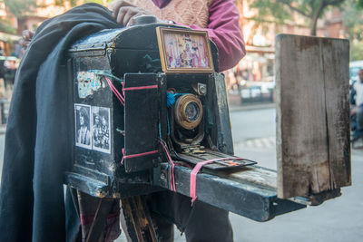 Close-up of person holding camera in city