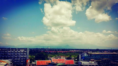 Cityscape against cloudy sky