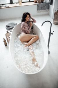 Beautiful woman sitting in bathtub