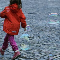 Rear view of boy playing with bubbles in water