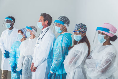 Doctors wearing mask standing against white background