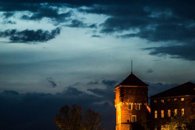 Silhouette of building against cloudy sky at night