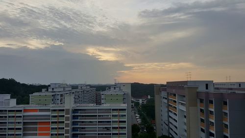 Buildings against cloudy sky