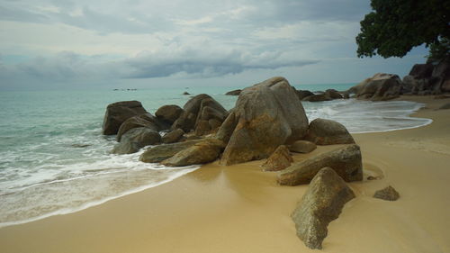 Rocks on beach against sky