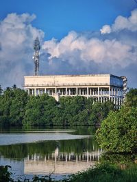 Buildings by lake against sky