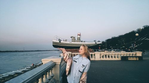 Man standing on boat in sea against clear sky