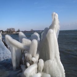 Snow on sea shore against sky