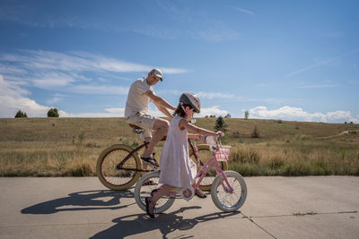 Dad looks to daughter as she learns to ride a bike without trainers