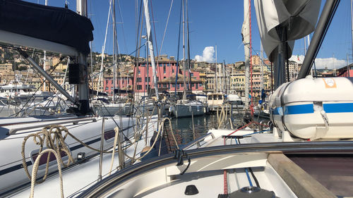 Sailboats moored in harbor against sky