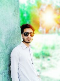 Portrait of young man wearing sunglasses standing outdoors