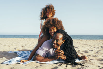 Happy man with daughters at beach