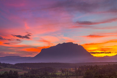 Scenic view of silhouette mountains against orange sky