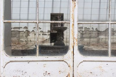 Reflection on glass window of abandoned building