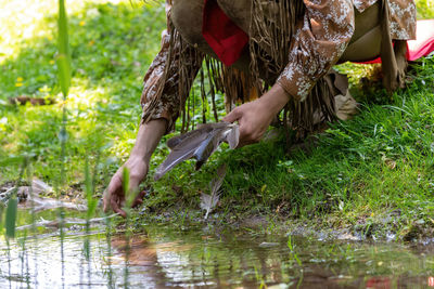 Low section of woman standing by lake