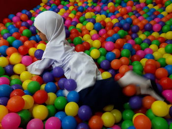 High angle view of girl playing on colorful balls