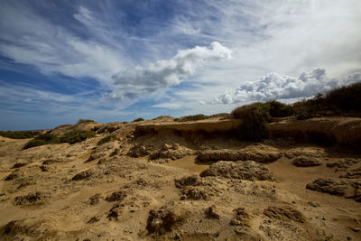 Scenic view of sand dunes against sky